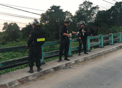 Hai người dân được trang bị áo giáp chống đạn hỗ trợ công an tìm nghi phạm bắn chết 4 người ở Củ Chi